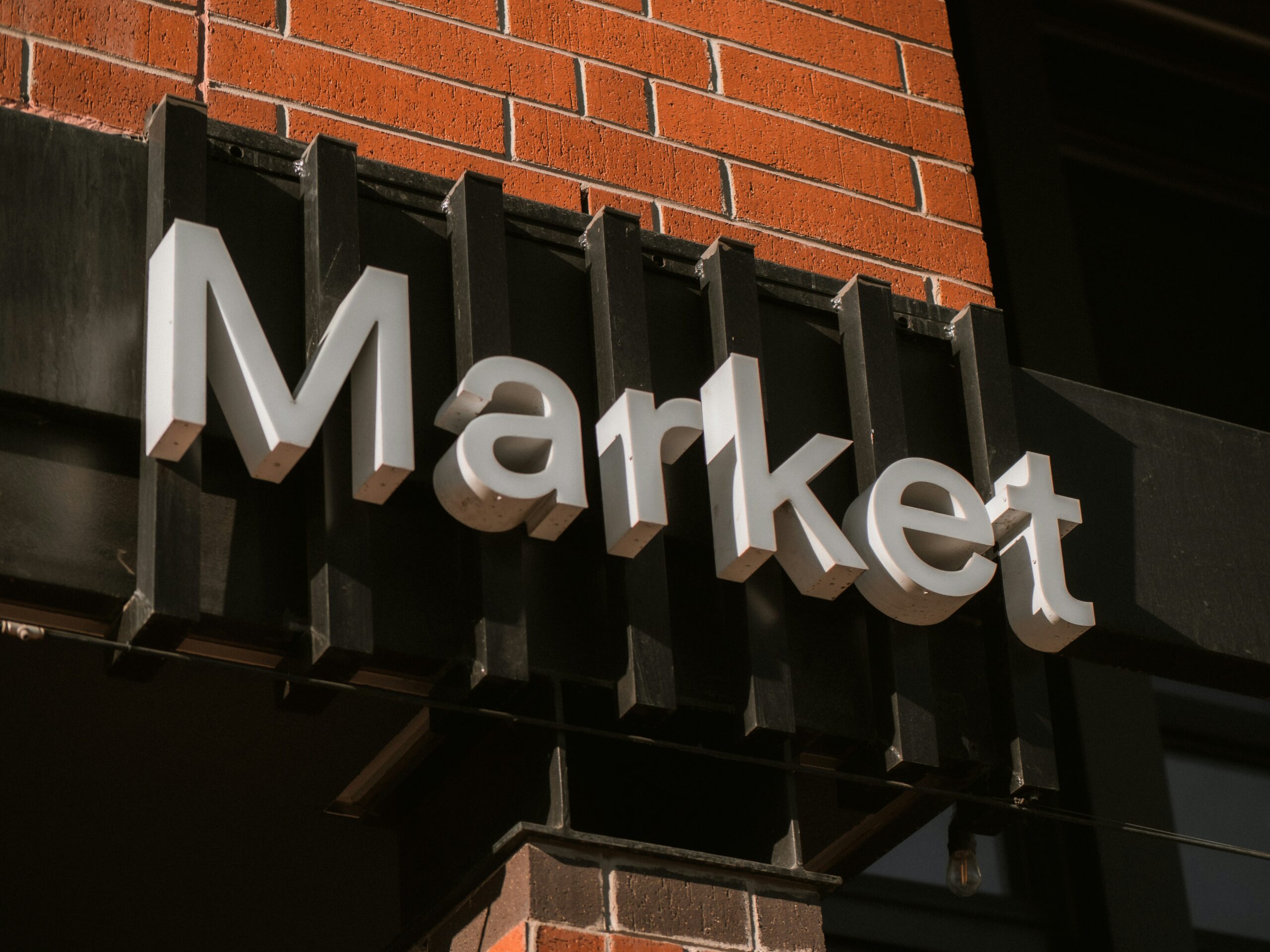 Exterior sign reading “Market” on a brick commercial building